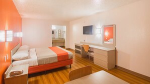 A hotel room with a bed, desk, chair, and a TV on the wall. - Motel 6 Lawton, OK (Lawton)