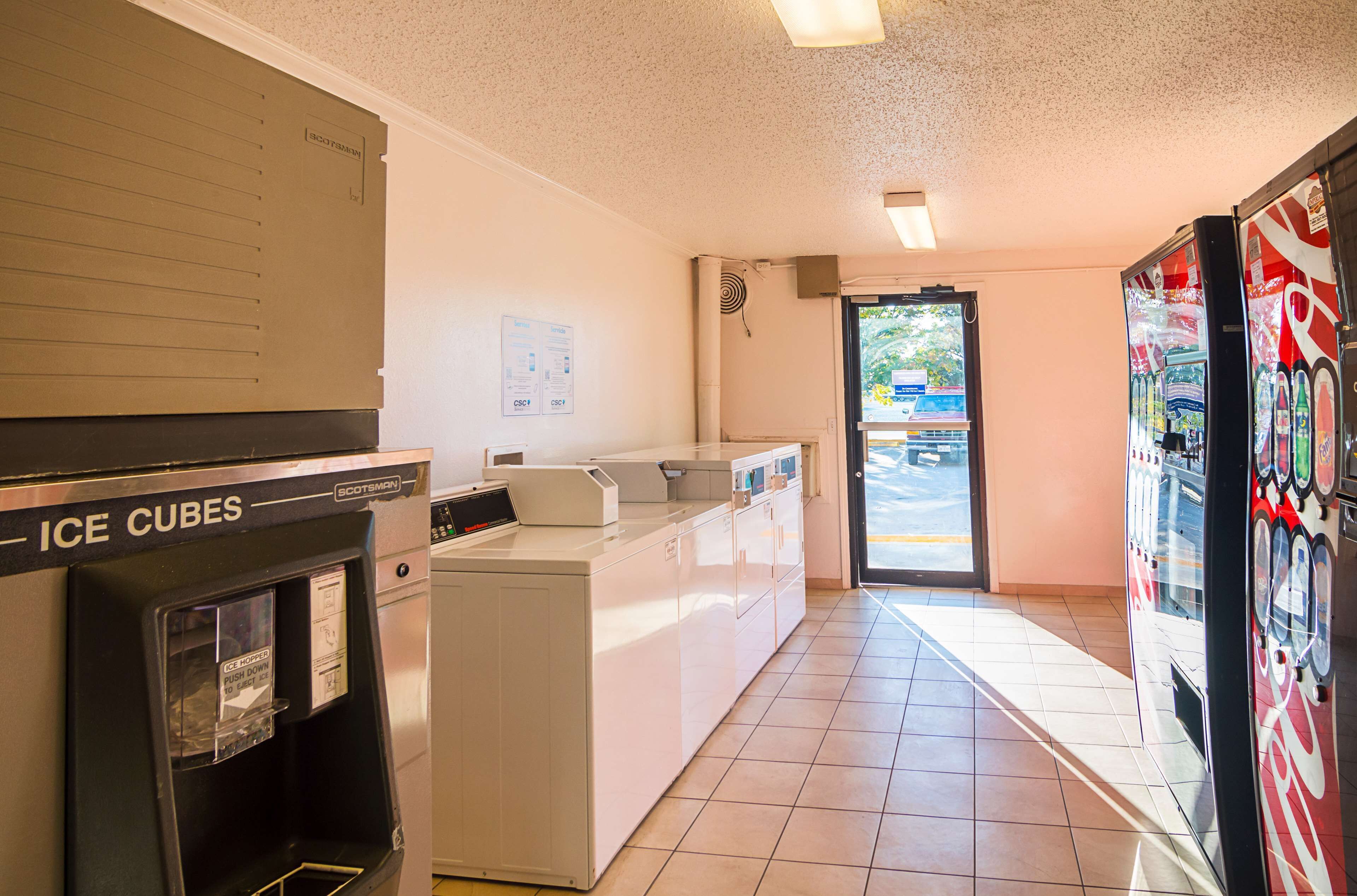 A hotel lobby with an ice dispenser, a washing machine, and a vending machine.