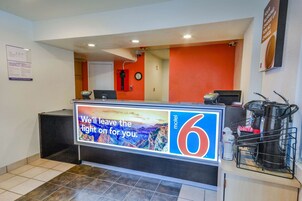 Uma receção de hotel com um grande anúncio de um motel 6 estrelas.