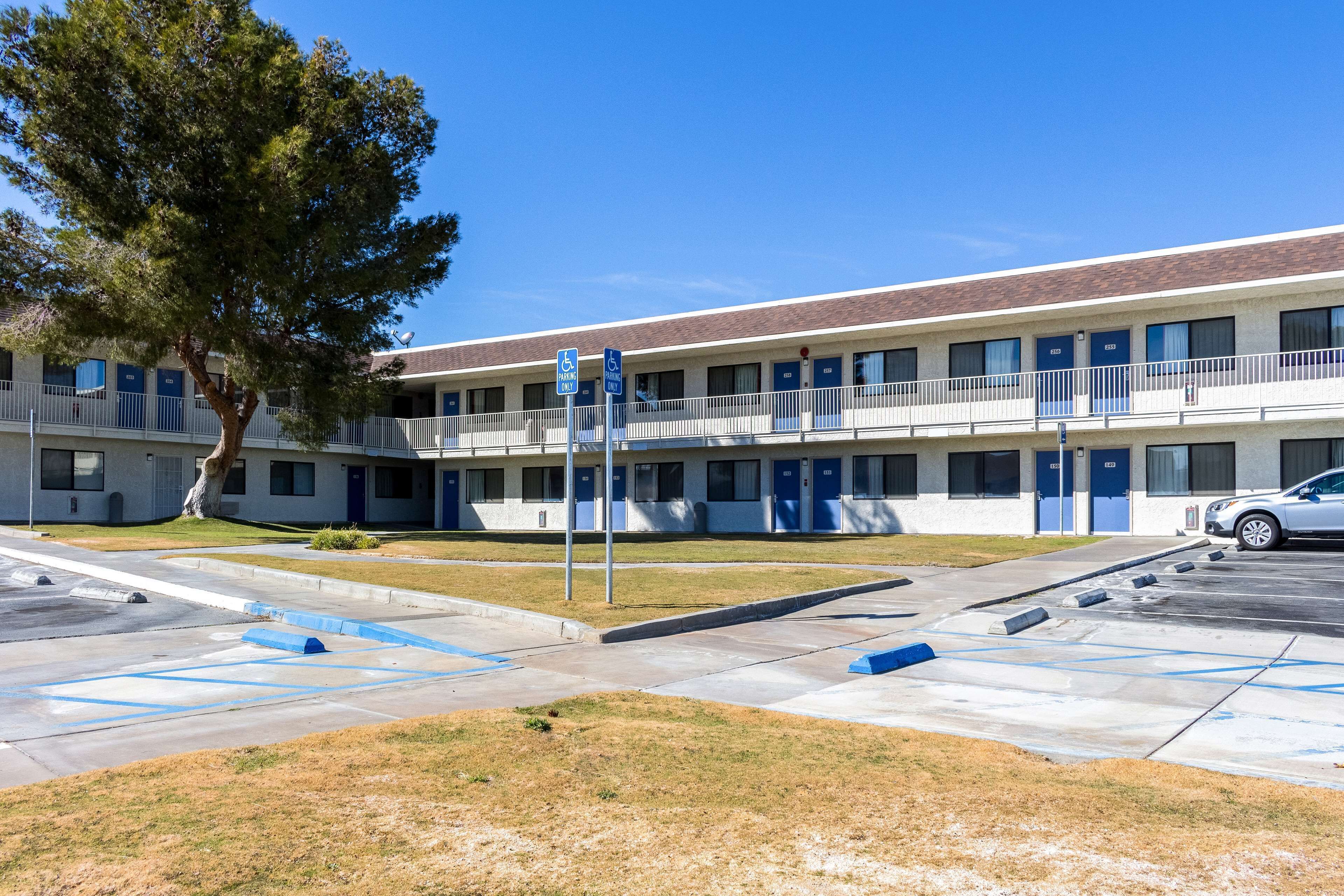 A motel with a two-story structure, multiple rooms, and a parking area.