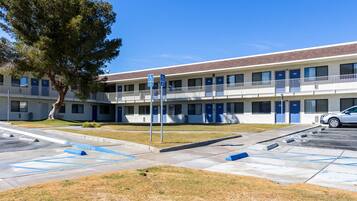 A motel with a two-story structure, multiple rooms, and a parking area.