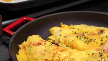 A skillet with scrambled eggs and a tray of fried eggs.