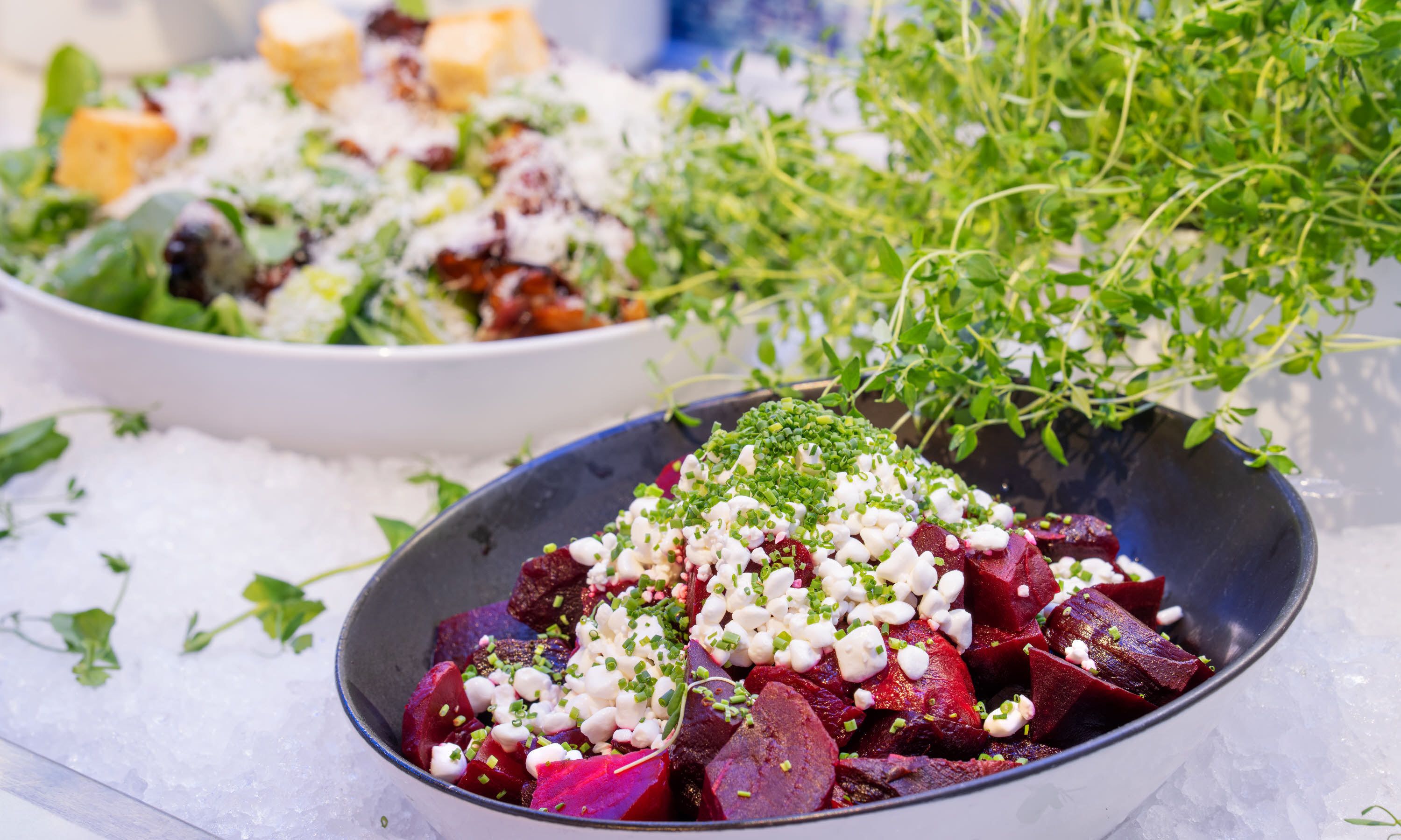A bowl of beetroot salad with cheese and herbs.
