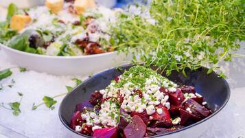 A bowl of beetroot salad with cheese and herbs.