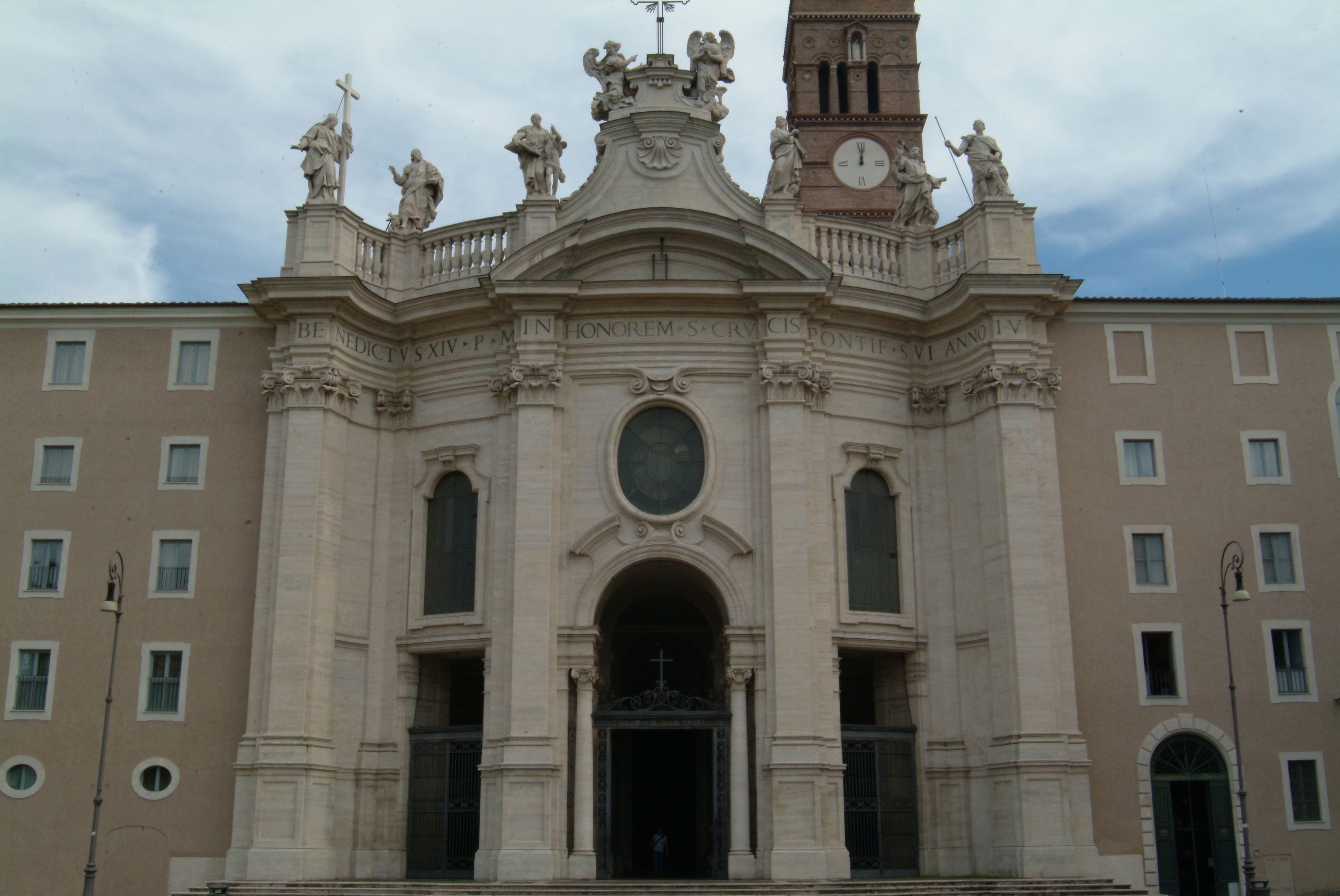 A historic building with a prominent clock tower and statues on the facade.