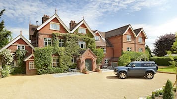 A large brick house with a driveway and a parked car.