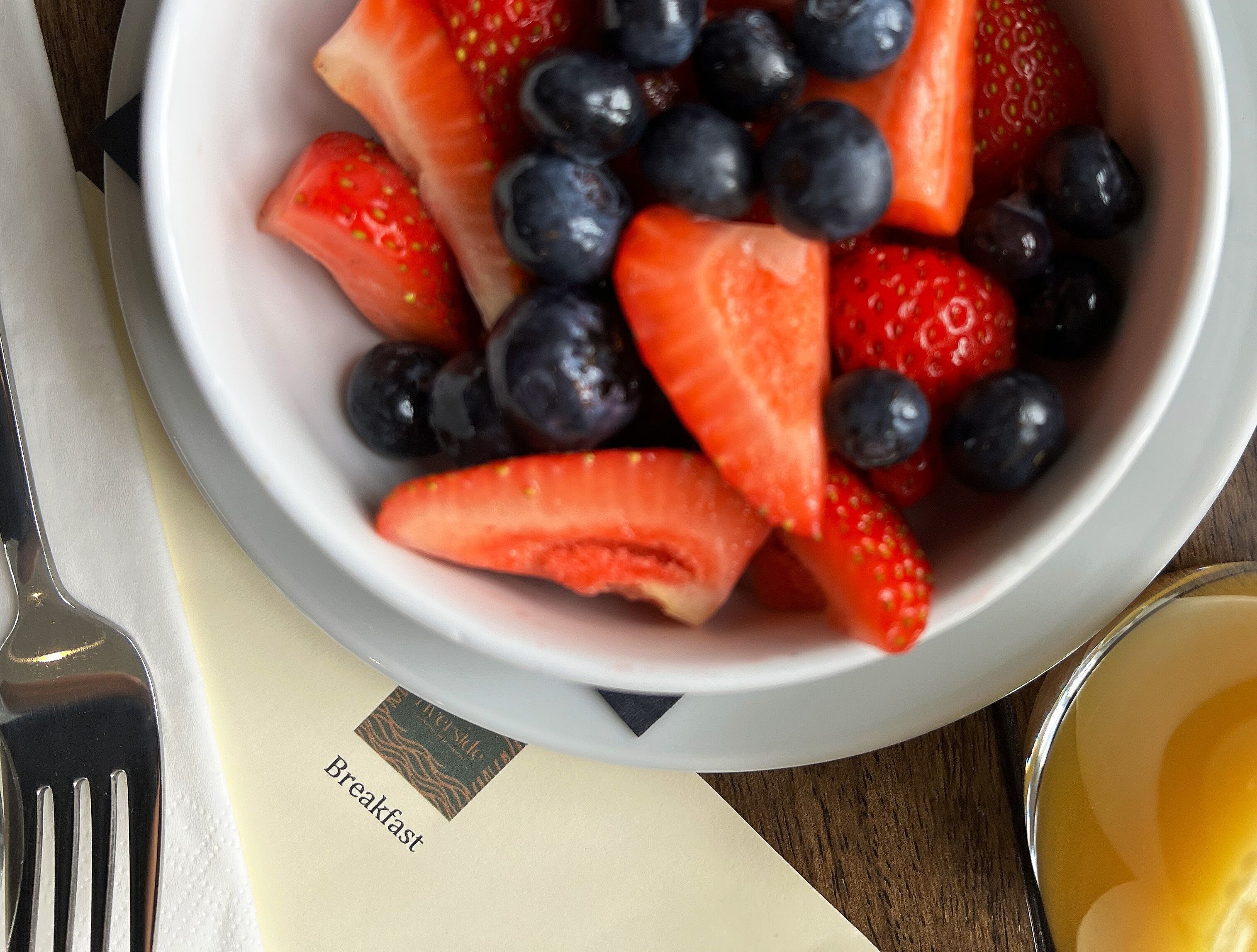 A bowl of mixed berries and a spoon.