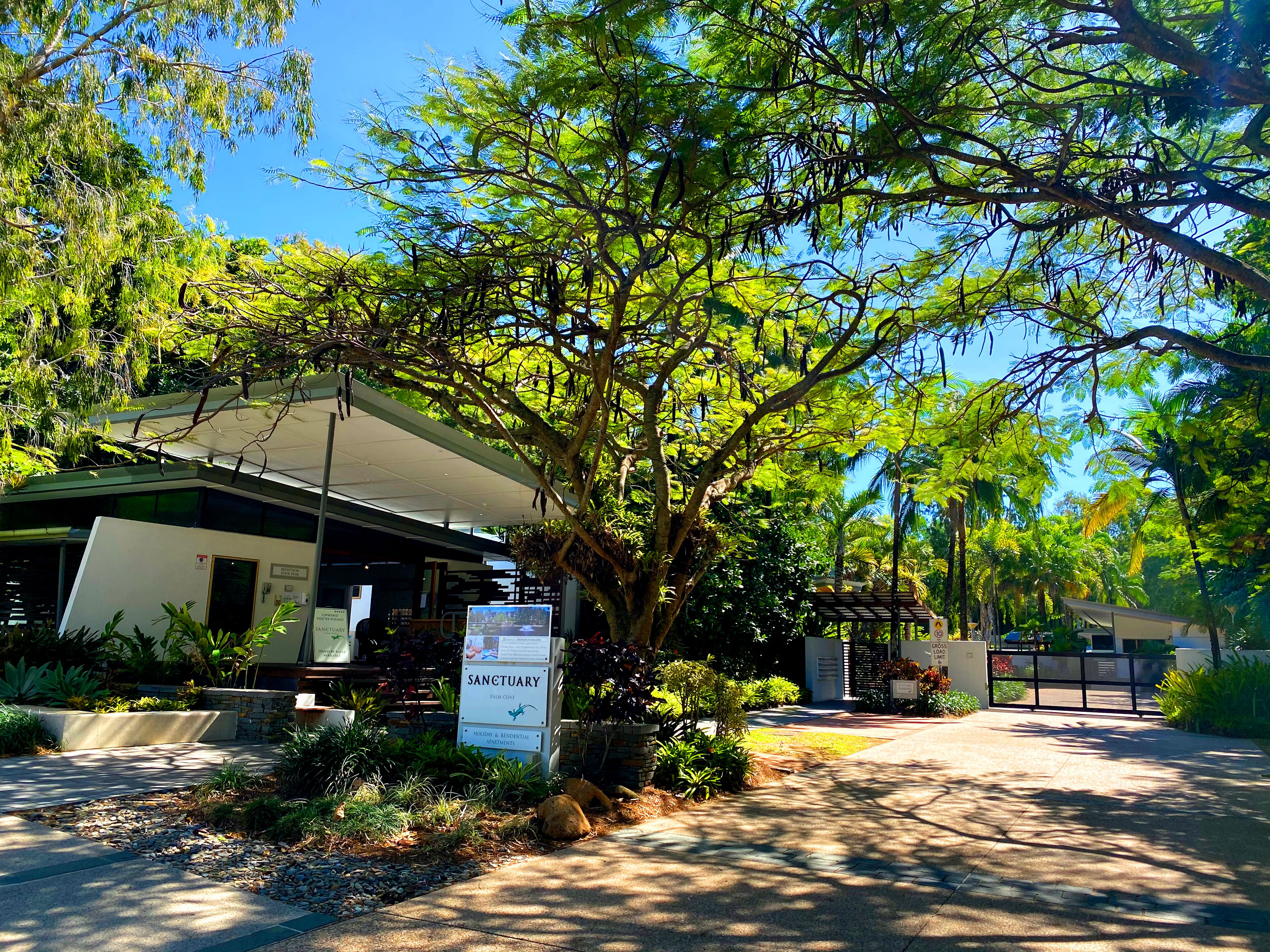 A building with a sign reading "Sanctuary" and a covered walkway.