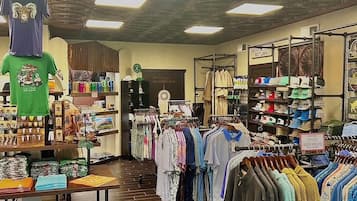 A clothing store with racks of clothes, a mannequin, and various items on shelves.