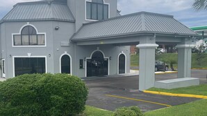 A two-story building with a grey facade, large windows, and a covered entrance area. - Red Roof Inn Orangeburg (Orangeburg)