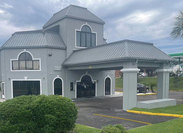 A two-story building with a grey facade, large windows, and a covered entrance area. - Red Roof Inn Orangeburg (Orangeburg)