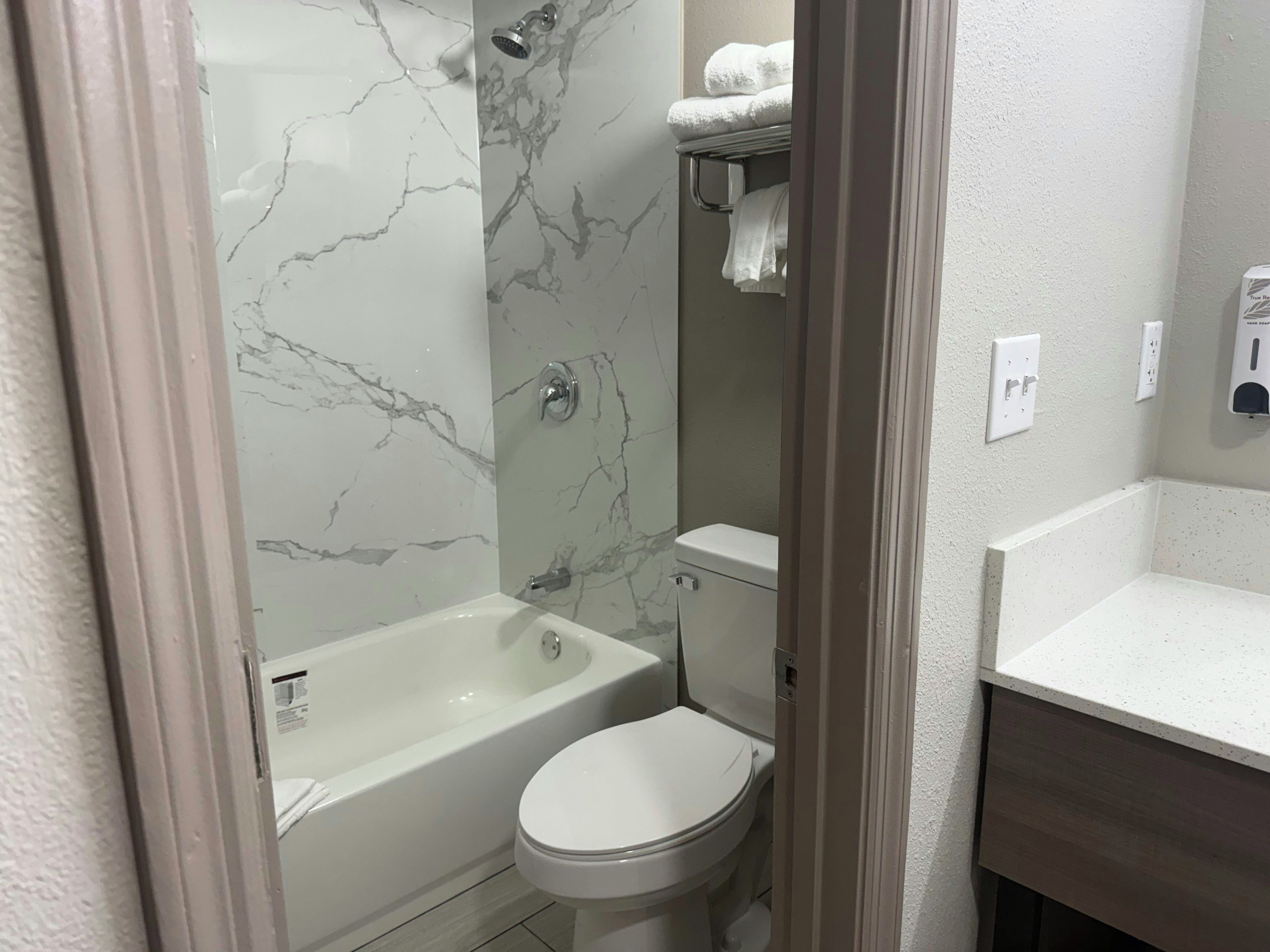 A bathroom with a bathtub, toilet, and a shower area.