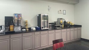A hotel reception area with a counter, coffee machines, and a refrigerator. - Red Roof Inn Orangeburg (Orangeburg)