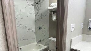 A bathroom with a bathtub, toilet, and a shower area. - Red Roof Inn Orangeburg (Orangeburg)