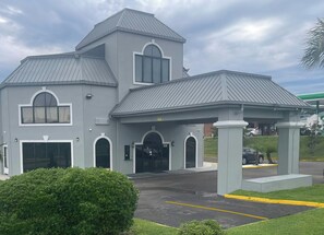 A two-story building with a grey facade, large windows, and a covered entrance area. - Red Roof Inn Orangeburg (Orangeburg)
