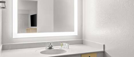 Un baño moderno con un espejo grande, un lavabo y un perchero para toallas.
