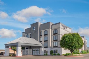 Un hotel DoubleTree by Hilton de diseño moderno, con un acceso cubierto y un gran árbol en la entrada.
