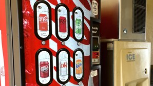 Distributore automatico Coca-Cola con diverse opzioni di bevande e un erogatore di ghiaccio affiancato.