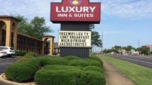 Segnaletica del Luxury Inn & Suites che evidenzia servizi come Wi-Fi gratuito, colazione, mini-frigorifero e suite con vasca idromassaggio.