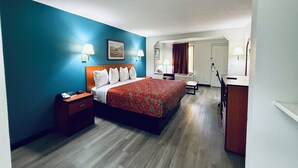 Una camera d'albergo con un letto, comodini, una scrivania, una sedia e uno specchio.