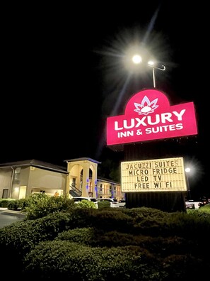 A sign for 'Luxury Inn & Suites' with amenities listed including Jacuzzi suites, micro fridge, LED TV, free WiFi, and a large illuminated sign. - Luxury Inn and Suites (Selma)