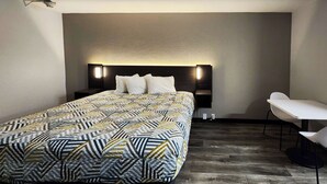 Una moderna camera d'albergo con un grande letto, un comodino, una sedia e un lampadario a parete.