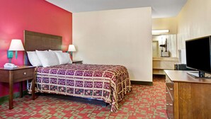A hotel room with a bed, bedside lamps, a TV, and a desk.