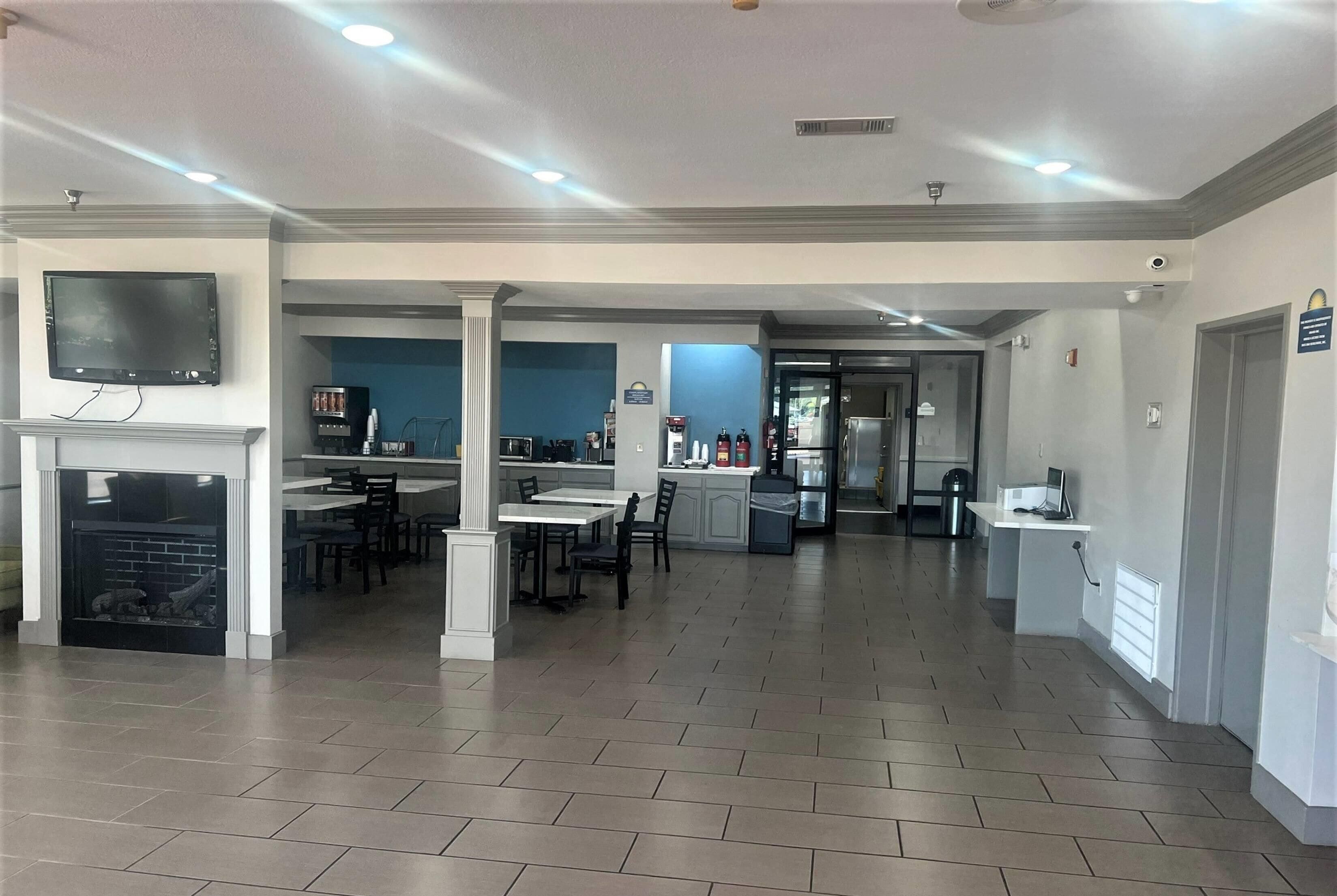 A spacious hotel lobby with a fireplace, a bar area, and a dining space.
