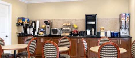 A hotel kitchen with a buffet setup, including a coffee station and various food items.