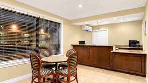 A kitchen with a dining table and chairs, a built-in oven, and a window with blinds. - Kingman Inn Route 66 I-40 (Kingman)