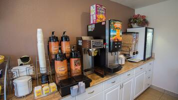 A coffee station with a coffee machine, cups, and coffee bags.