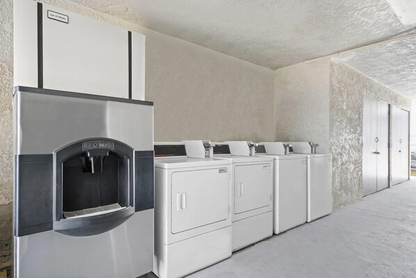A laundry facility with a water dispenser and multiple washing machines.
