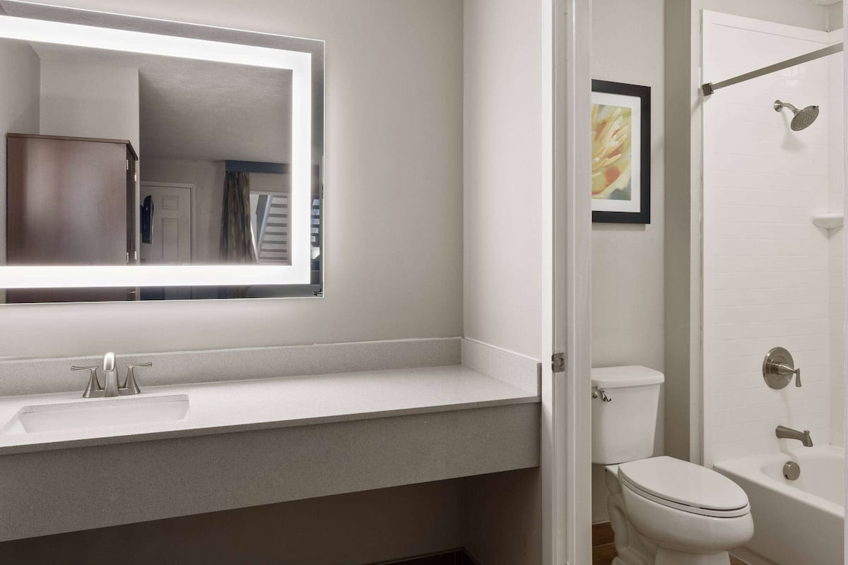 Un baño con lavamanos, inodoro y bañera blancos.