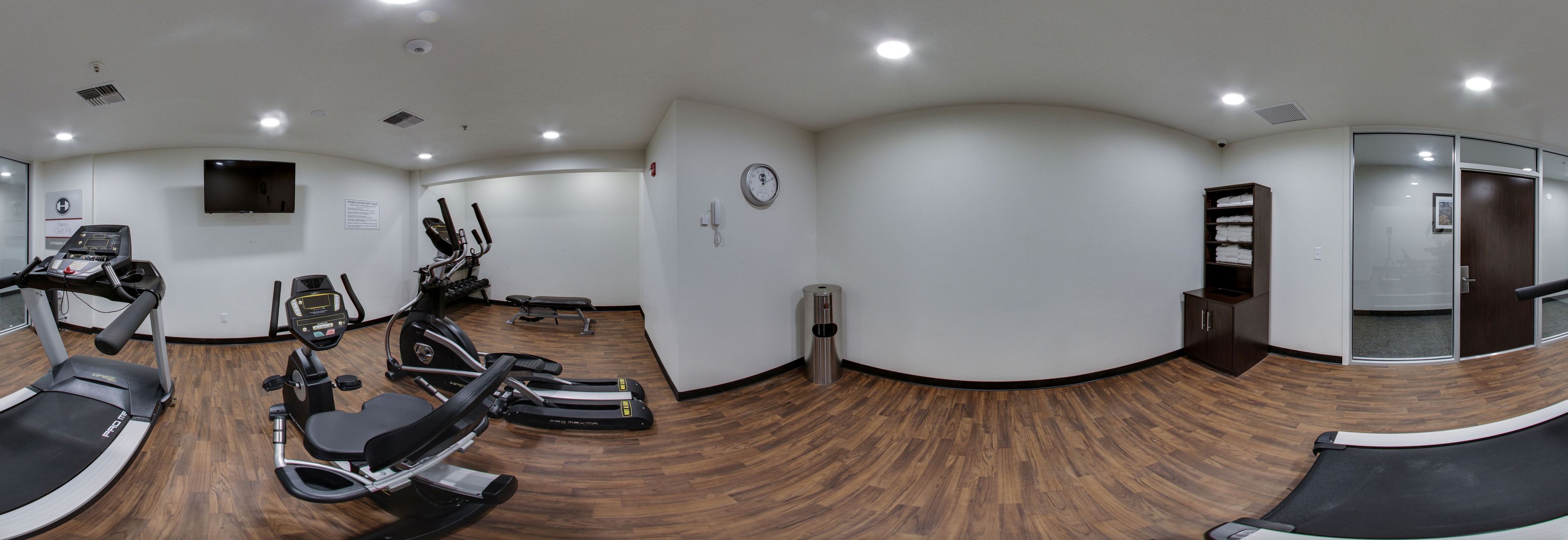 Une salle de sport équipée de tapis de course, de vélos elliptiques et d’un vélo d’appartement.