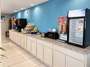 A breakfast bar with a coffee machine, toaster, and refrigerator stocked with beverages. - Days Inn by Wyndham Russell (Russell)