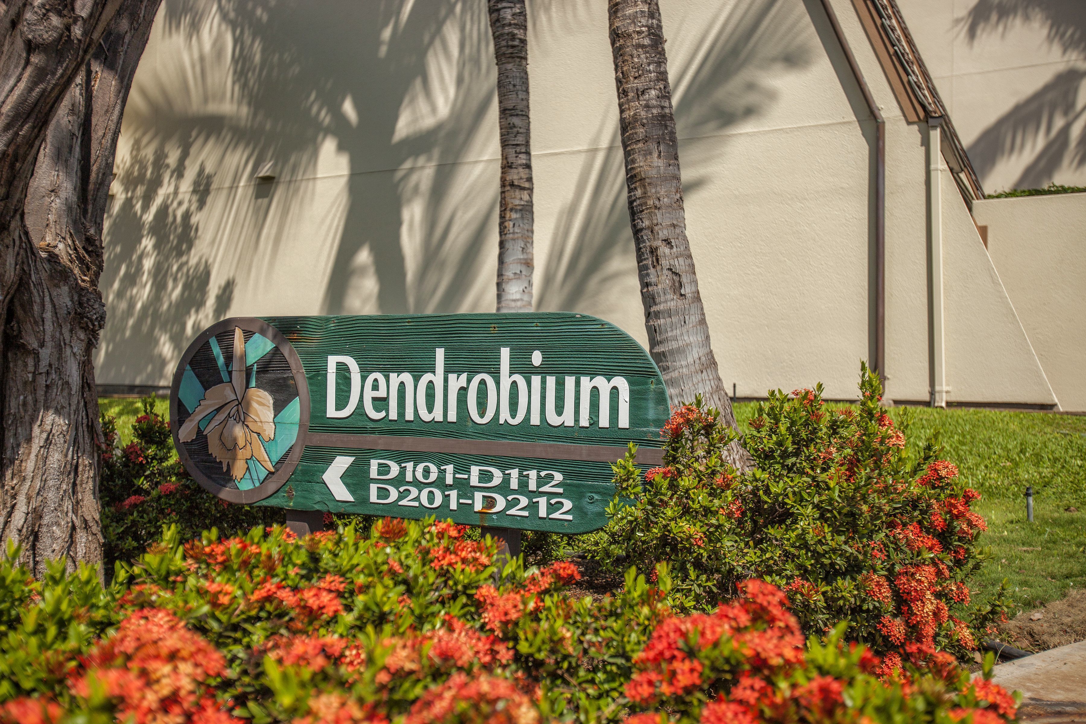 A sign for 'Dendrobium' with directional arrows and address codes.