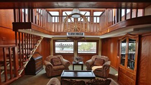 A wooden interior with a staircase, two armchairs, a sofa, and a table. - Delta King Hotel (Sacramento)