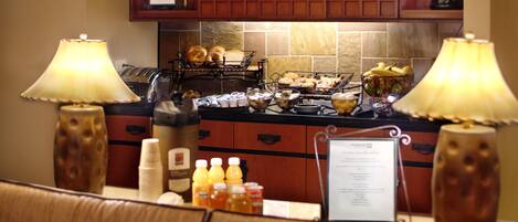 A kitchen with a breakfast bar, a coffee station, and a menu sign.