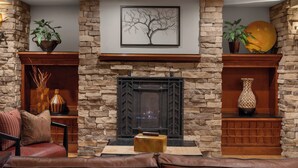 A cozy living room with a stone fireplace, leather sofa, and decorative items.
