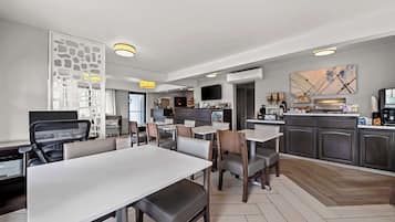 A modern restaurant with a dining area, kitchen, and bar/lounge area.