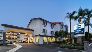 Un hotel Best Western de estructura de dos pisos, con múltiples espacios de estacionamiento y un área ajardinada con palmeras.