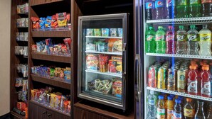 A vending machine with snacks and drinks, and a refrigerator with beverages. - Fairfield by Marriott Kalamazoo West (Kalamazoo)