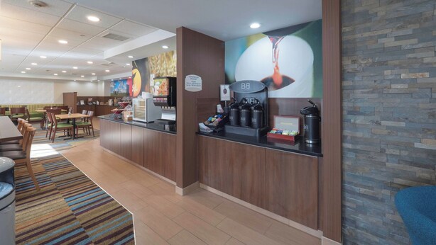 Ein Hotel-Rezeptionsbereich mit Theke, Sitzgelegenheiten und einer Wand mit Wandgemälde.