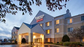 Ein Fairfield Inn & Suites Marriott Hotel mit überdachter Einfahrt, mehreren Etagen und einem Parkplatz.