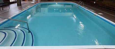 An indoor swimming pool with a 'NO DIVING' sign and a '3 FT DEPTH' marking.