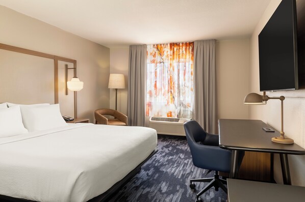 A hotel room with a bed, desk, chair, and a large window with curtains. - Fairfield Inn & Suites Minneapolis St. Paul / Roseville (Roseville)