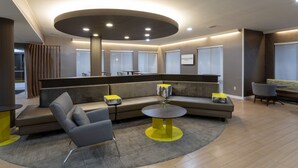 A modern lounge area with a curved sofa, a round table, and a seating area with chairs.