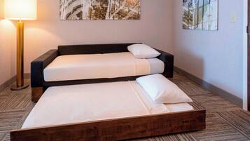 A double bed with a wooden frame, a bedside lamp, and two abstract wall paintings.