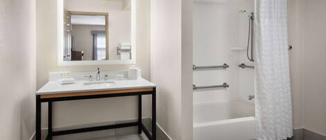 Une salle de bain moderne avec un lavabo blanc, un miroir et une baignoire.