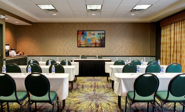 A conference room with tables, chairs, and a podium. - Hilton Garden Inn Albany Airport (Albany)
